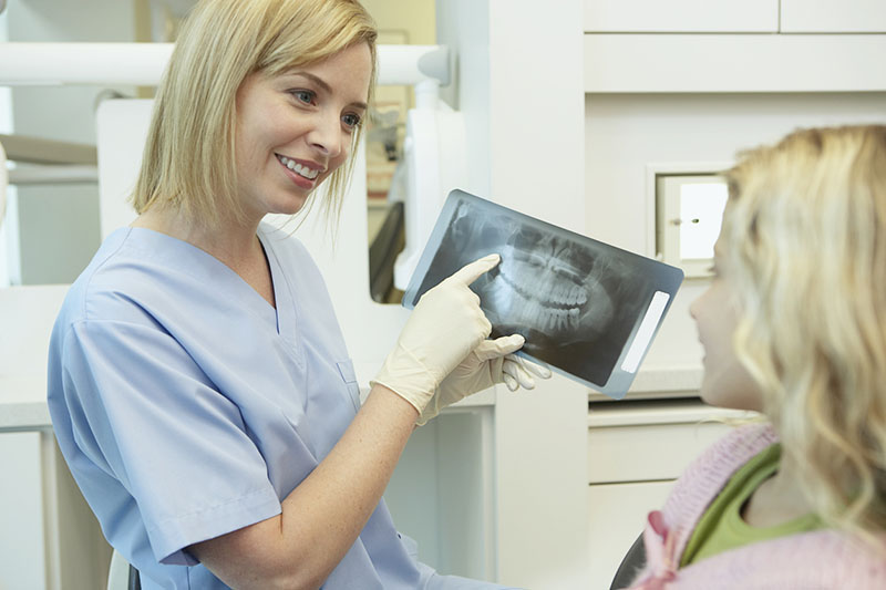 Dentist showing x-ray to patient