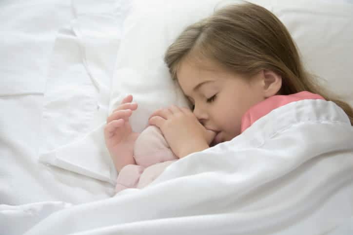 A child sucking their thumb as they sleep.