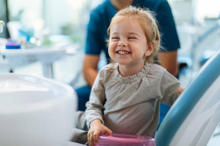 A child smiling while at the dentist's office.