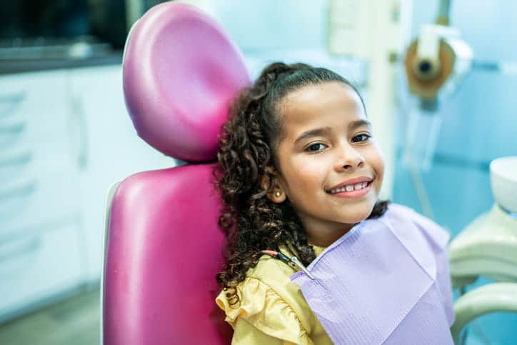 A child smiling while at the dentist's office.