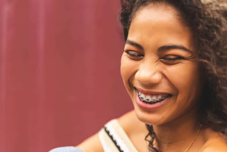 A woman smiling with metal braces.